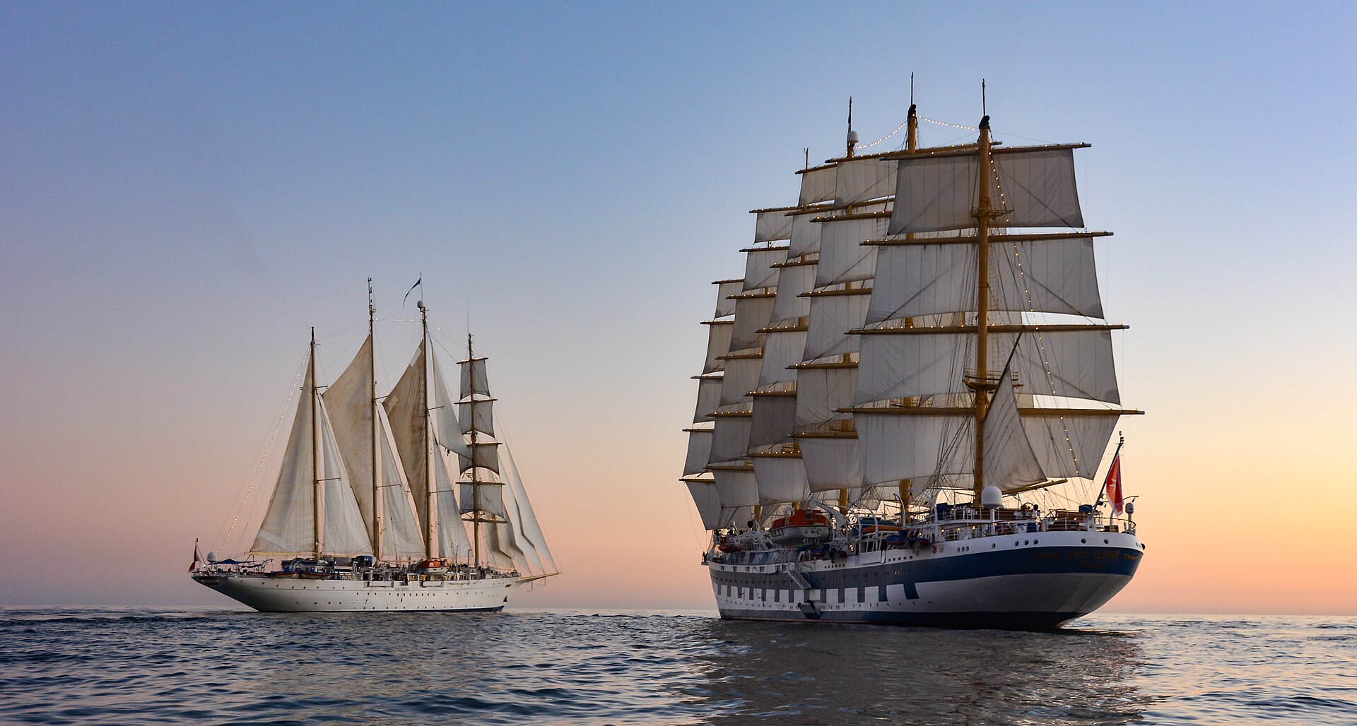 Sailing ships Star Clipper and Royal Clipper under full sail at dusk