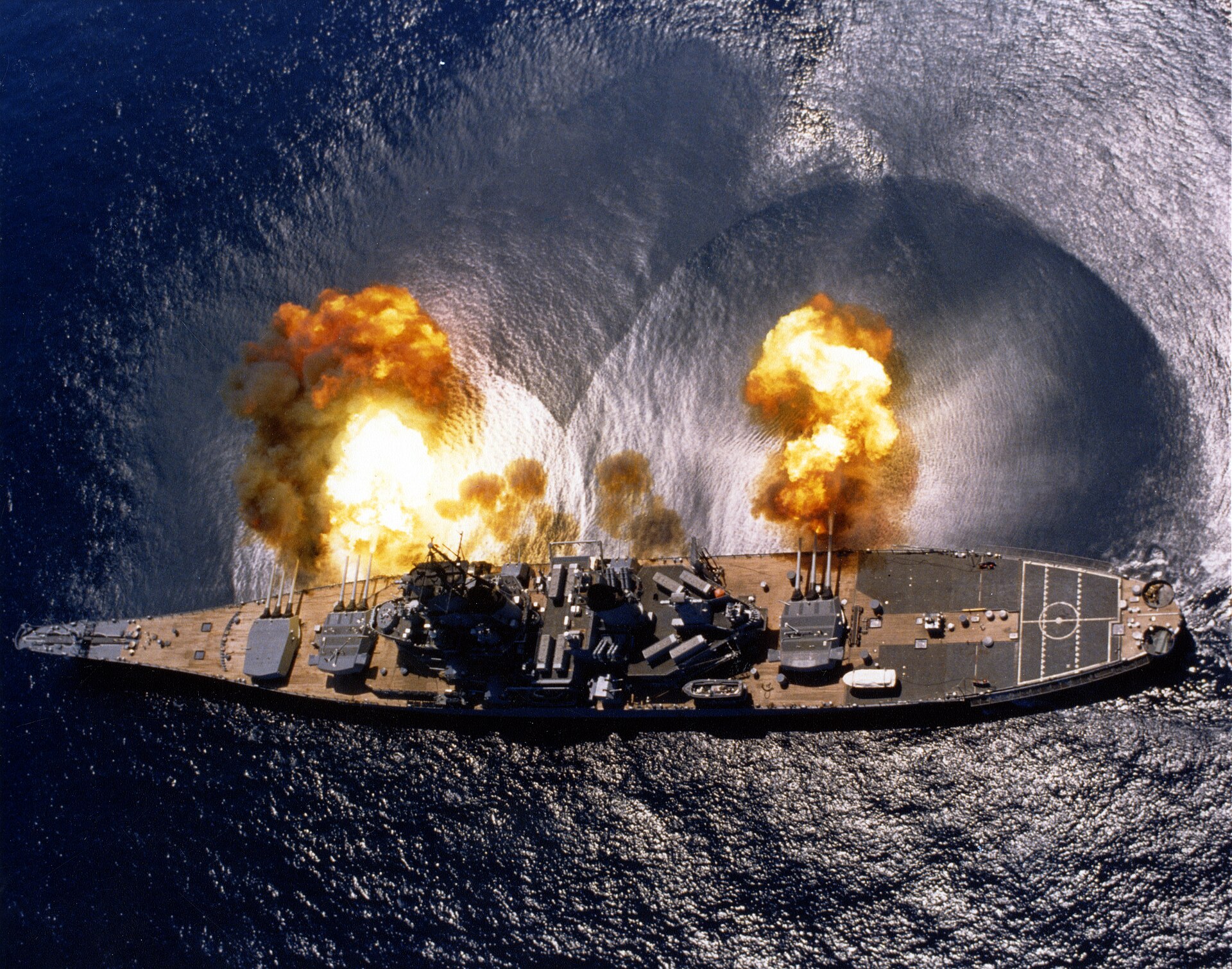 USS Iowa firing a full broadside, seen from the air